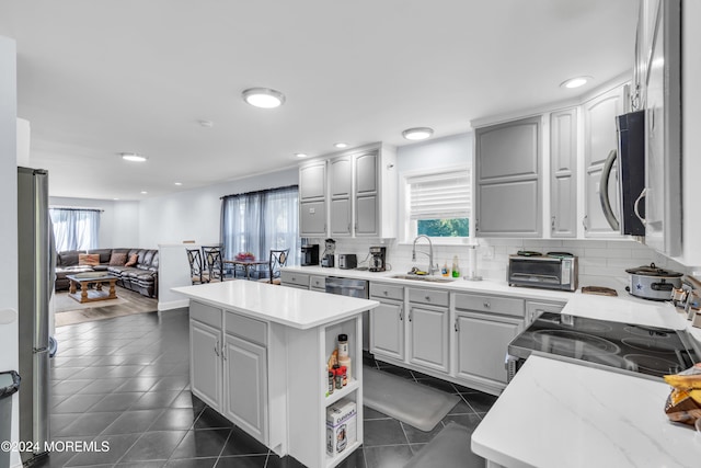 kitchen featuring a kitchen island, dark hardwood / wood-style floors, stainless steel appliances, backsplash, and sink