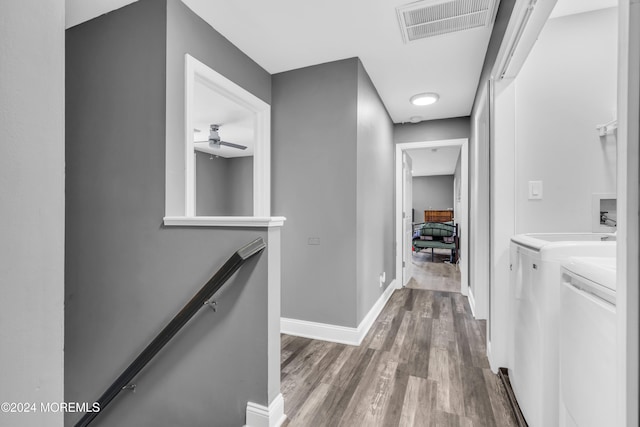 corridor featuring independent washer and dryer and hardwood / wood-style floors