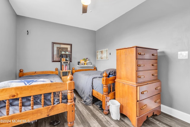 bedroom with ceiling fan, wood-type flooring, and vaulted ceiling