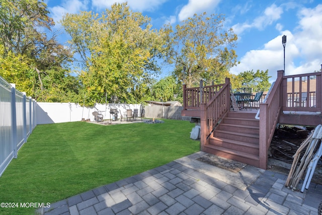 view of yard featuring a deck and a patio