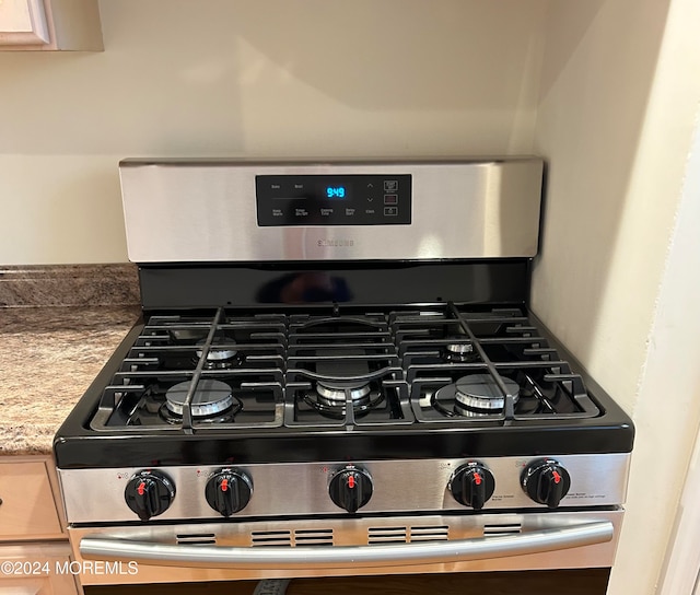 room details with gas range and light brown cabinets