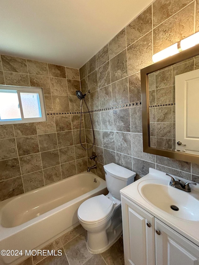 full bathroom with vanity, toilet, tile walls, and tiled shower / bath