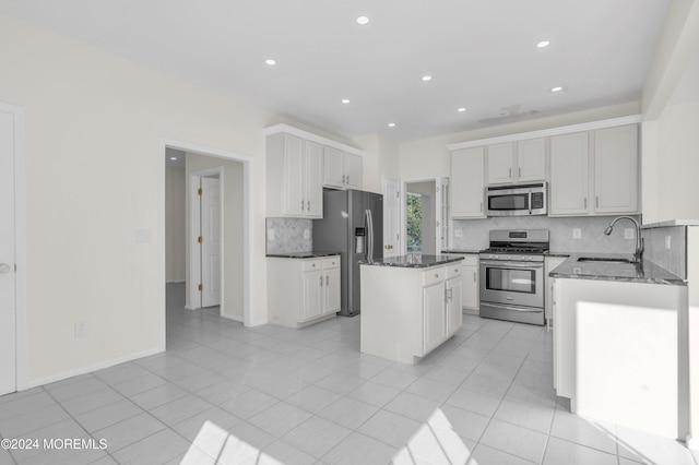 kitchen with stainless steel appliances, decorative backsplash, sink, and a kitchen island