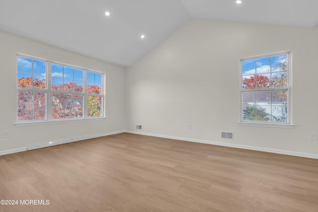 empty room featuring light hardwood / wood-style flooring and high vaulted ceiling