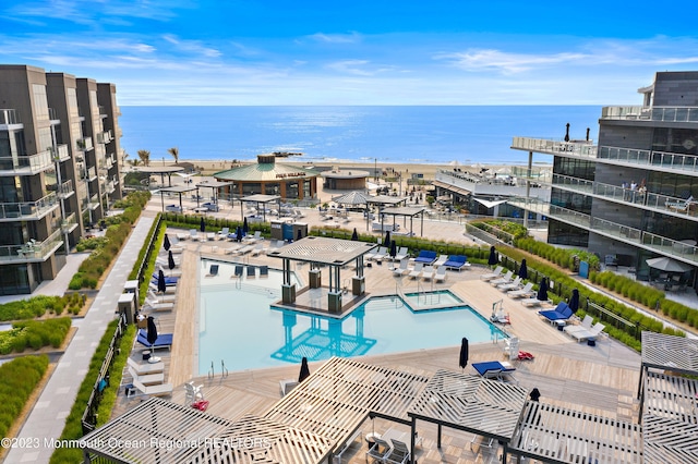 view of pool featuring a water view and a patio