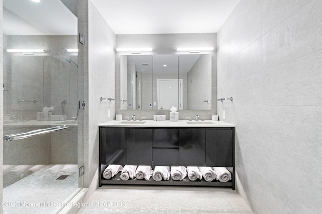 bathroom with vanity, walk in shower, and tile walls