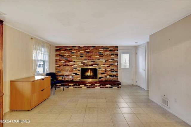 tiled living room with crown molding and a fireplace