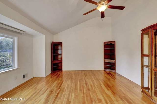 empty room featuring ceiling fan, light wood-type flooring, and vaulted ceiling