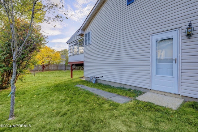 view of side of home with a yard