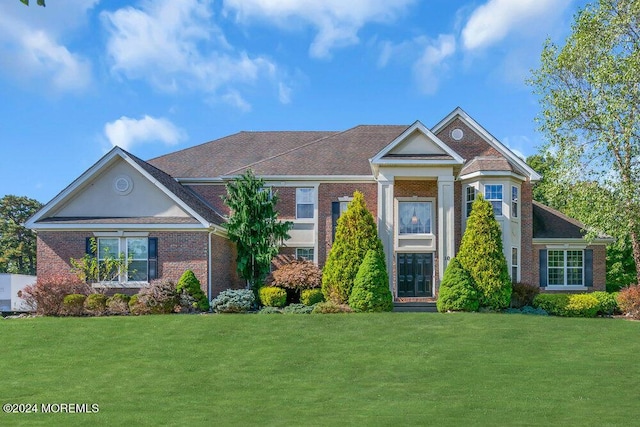 view of front of home featuring brick siding and a front yard