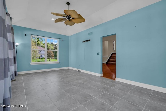 spare room with visible vents, baseboards, lofted ceiling, ceiling fan, and stairs