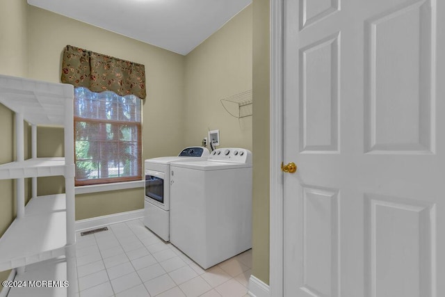 washroom with light tile patterned flooring, laundry area, visible vents, baseboards, and washing machine and clothes dryer