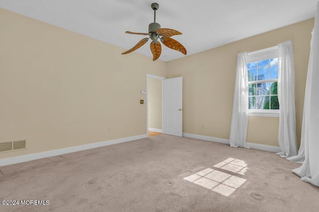 carpeted spare room with visible vents, ceiling fan, and baseboards