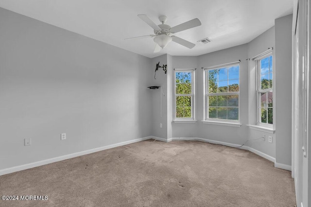 spare room with ceiling fan, visible vents, baseboards, and carpet flooring