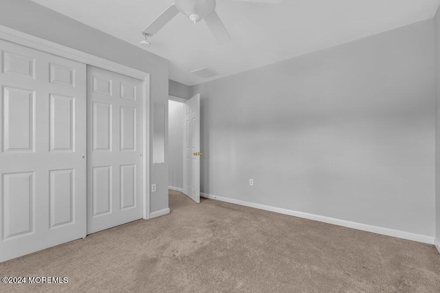 unfurnished bedroom featuring a ceiling fan, a closet, baseboards, and carpet flooring