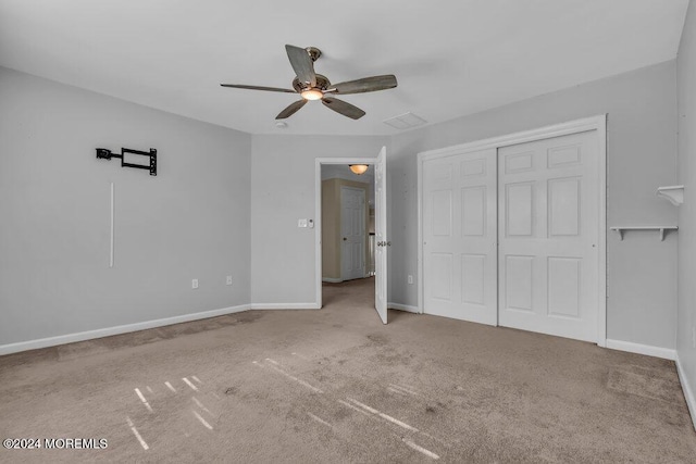 unfurnished bedroom featuring a ceiling fan, a closet, carpet flooring, and baseboards