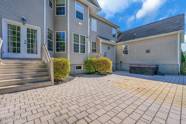 rear view of house with french doors, a patio area, and a hot tub