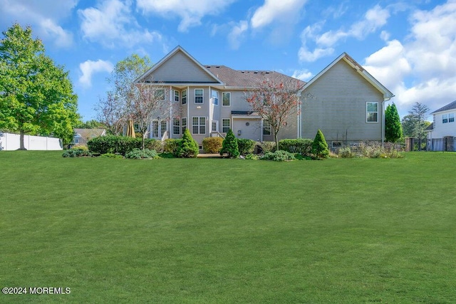 back of house featuring a yard and fence