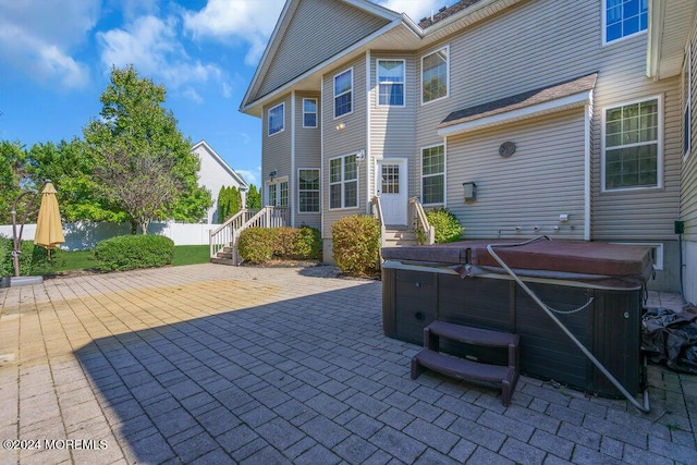 view of patio / terrace with fence and a hot tub