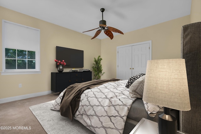 bedroom featuring ceiling fan, a closet, baseboards, and carpet flooring