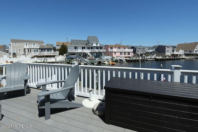 wooden terrace with a residential view, a boat dock, and a water view