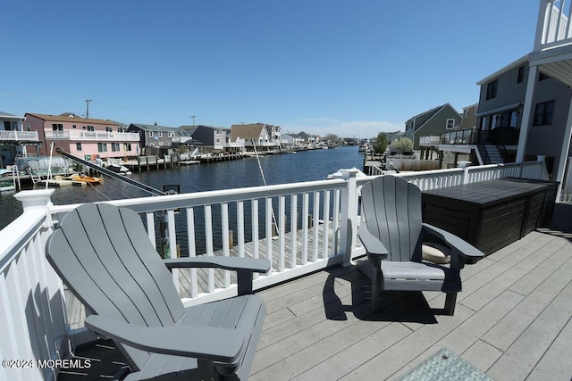 wooden terrace with a residential view and a water view
