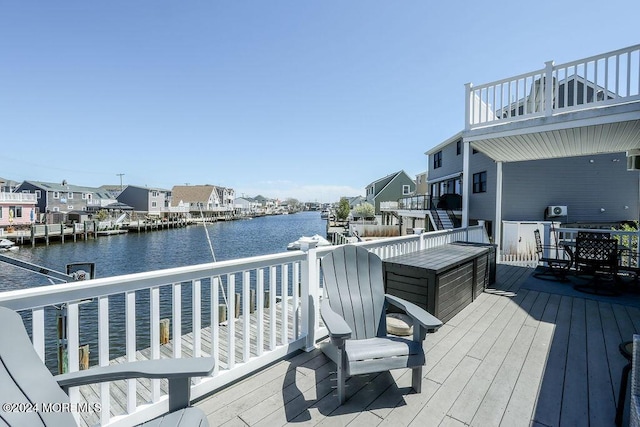 wooden terrace with a water view and a residential view