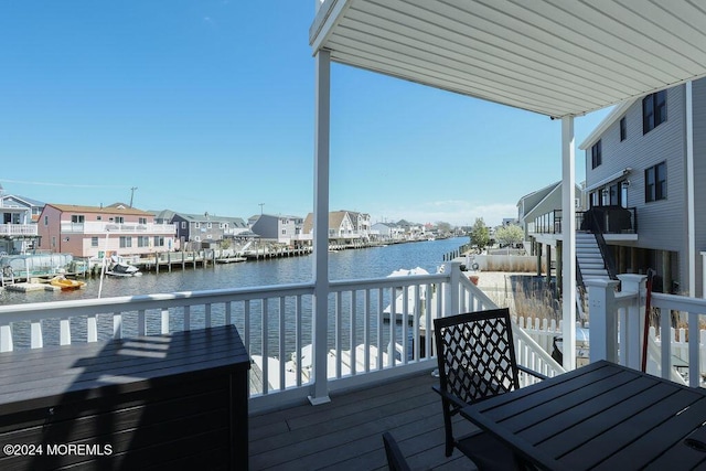 deck featuring a residential view, a water view, and stairway