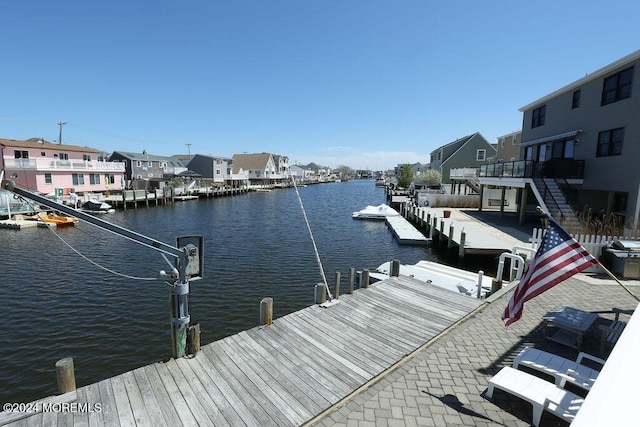 view of dock featuring a water view and a residential view