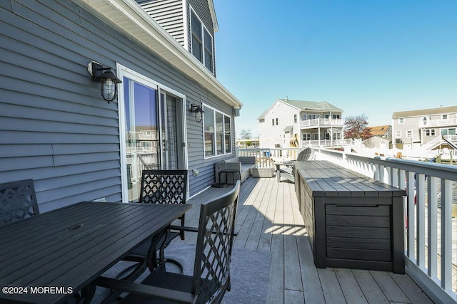wooden terrace with a residential view and outdoor dining space
