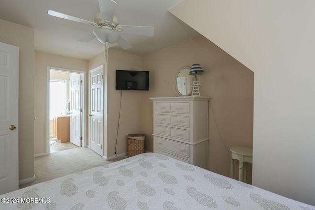 carpeted bedroom featuring baseboards, ceiling fan, and ensuite bathroom