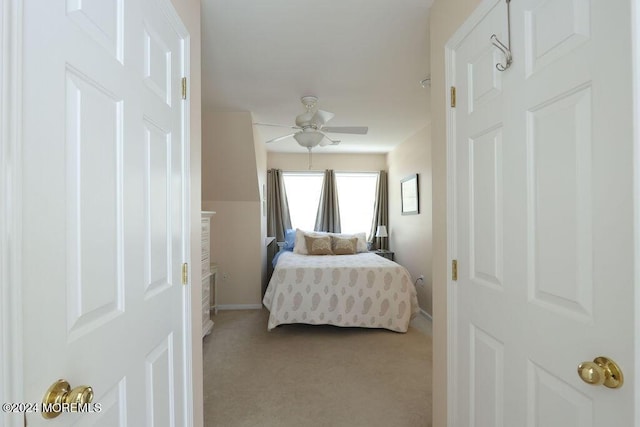 bedroom featuring baseboards, ceiling fan, and light colored carpet
