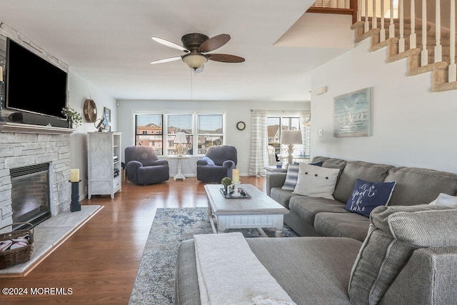 living room featuring wood-type flooring, a fireplace, and ceiling fan