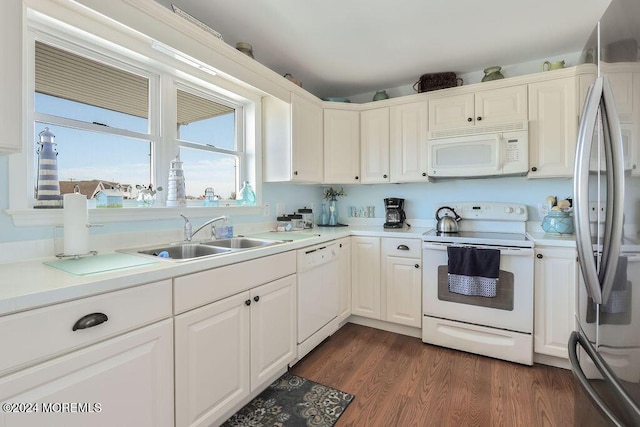 kitchen with dark wood finished floors, a sink, light countertops, white appliances, and white cabinetry