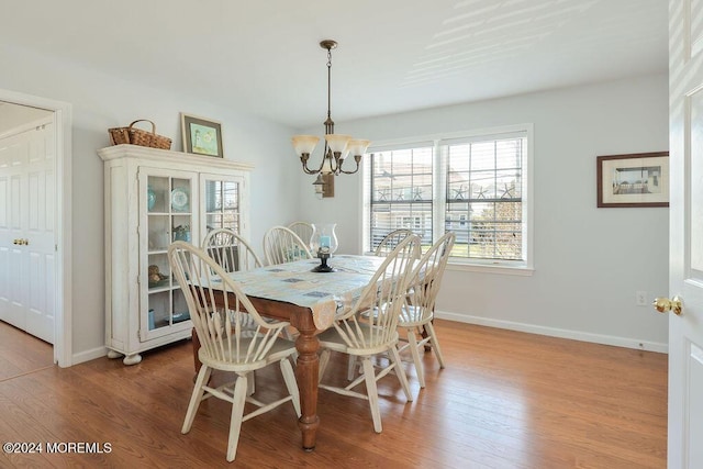 dining area featuring baseboards, an inviting chandelier, and wood finished floors