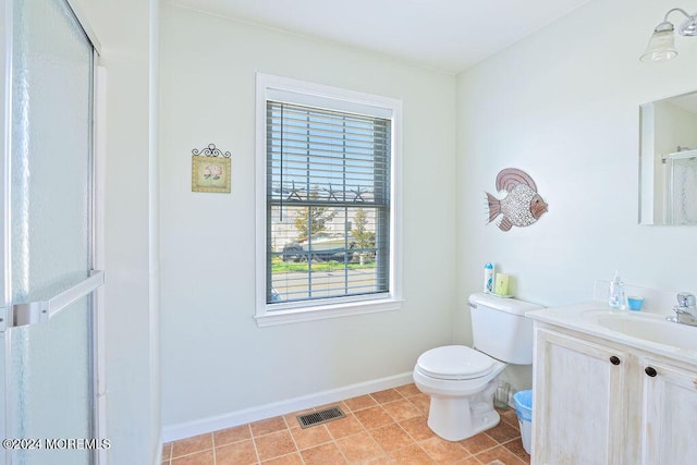 bathroom featuring visible vents, vanity, a shower with door, toilet, and baseboards
