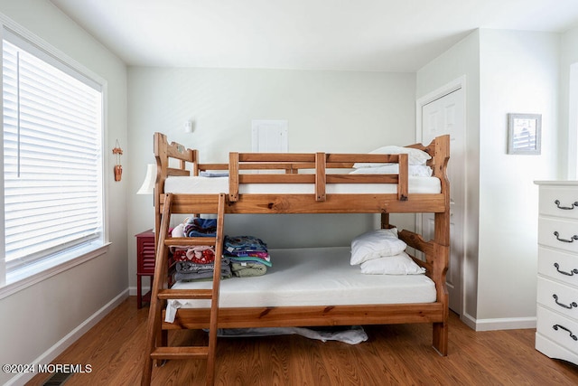 bedroom with multiple windows and hardwood / wood-style floors