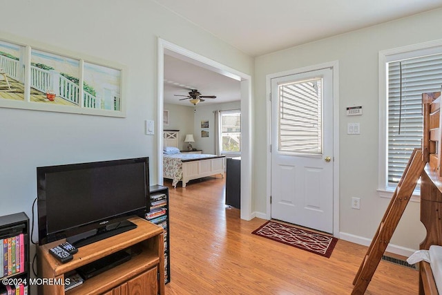 entryway with a ceiling fan, baseboards, and light wood finished floors