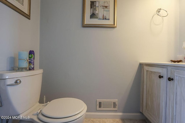 bathroom with baseboards, vanity, toilet, and visible vents