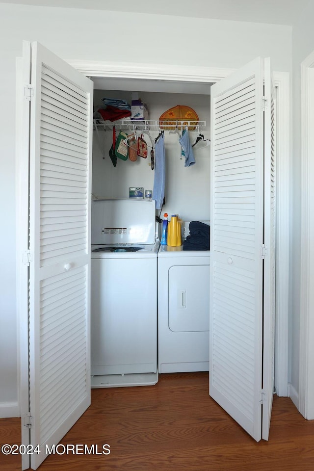 washroom with laundry area, wood finished floors, and washer and clothes dryer