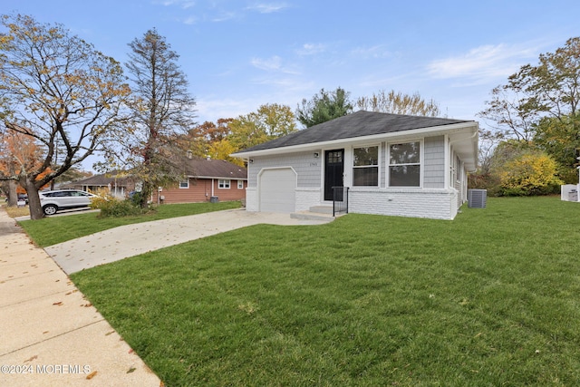 view of front of property with central AC, a front lawn, and a garage