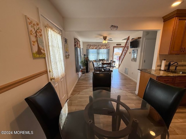 dining space featuring ceiling fan and sink