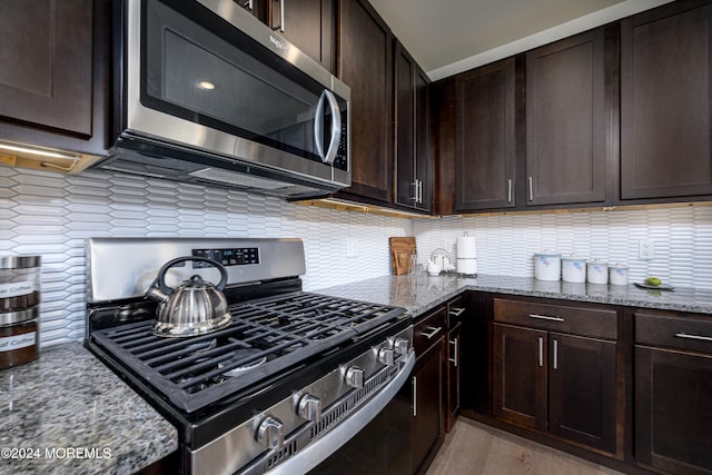 kitchen featuring decorative backsplash, appliances with stainless steel finishes, light stone counters, and dark brown cabinets