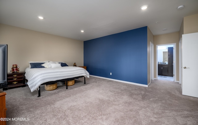 bedroom with connected bathroom and carpet floors