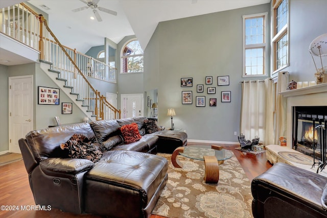 living room with plenty of natural light, ceiling fan, light wood-type flooring, and high vaulted ceiling