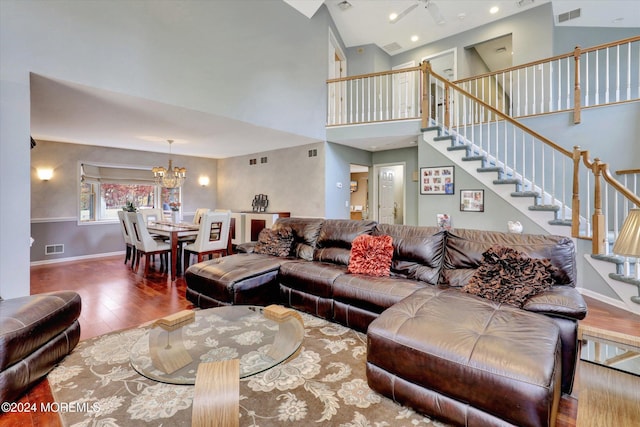 living room featuring hardwood / wood-style floors, high vaulted ceiling, and a chandelier