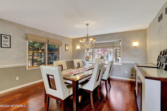 dining area featuring plenty of natural light, dark hardwood / wood-style flooring, and an inviting chandelier