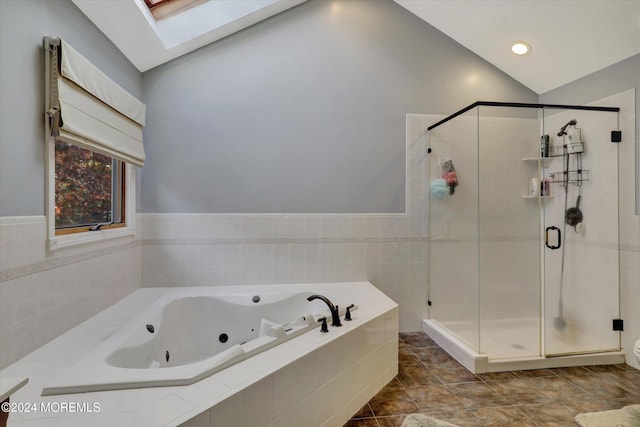 bathroom featuring tile patterned floors, lofted ceiling with skylight, and independent shower and bath