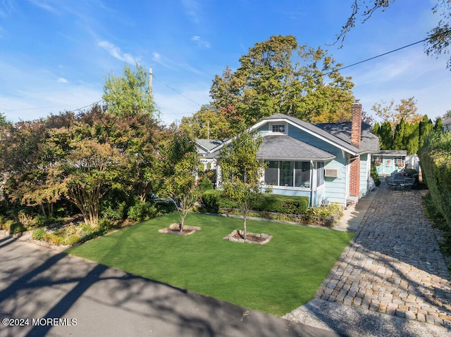 view of front of house featuring a front yard and a sunroom