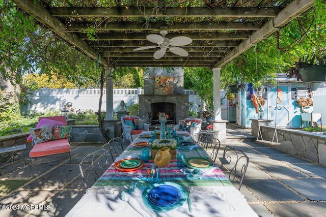 view of patio / terrace featuring a pergola, ceiling fan, and exterior fireplace